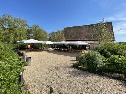 Entfernter Blick auf den Biergarten mit Schirmen, blauer Himmel