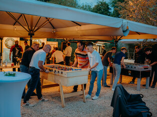 Blick in den Biergarten mit Gästen am Tischkicker