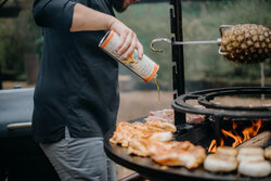 Koch am Grill mit Ölflasche